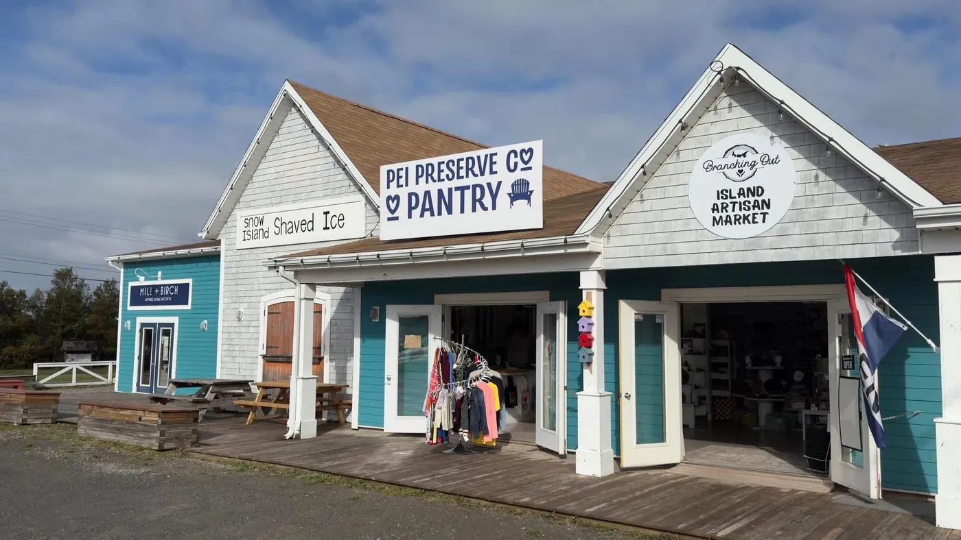 The Branching Out Island Artisan Market shop in Cavendish: teal doors under a round Branching Out sign, beside PEI Preserve Co. Pantry