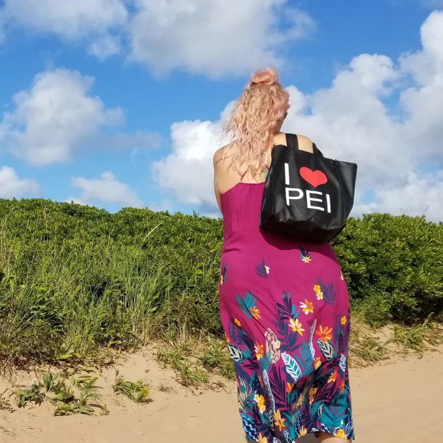 Carrying an I Love PEI tote by the shore