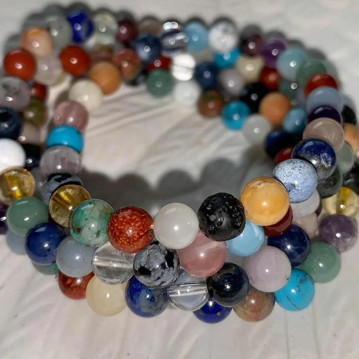 A pile of mixed crystal bracelets by Nora Cummins, Energy Intuitive