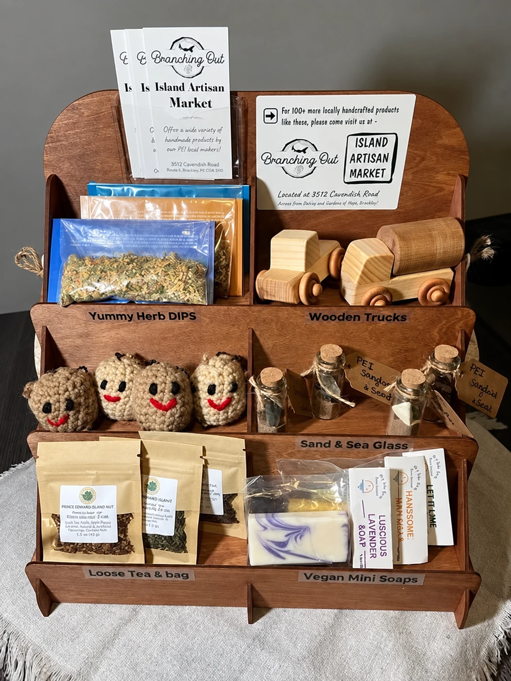 A wooden shelf display of makers&rsquo; goods with Branching Out cards: wooden toy cars, sachets and soaps